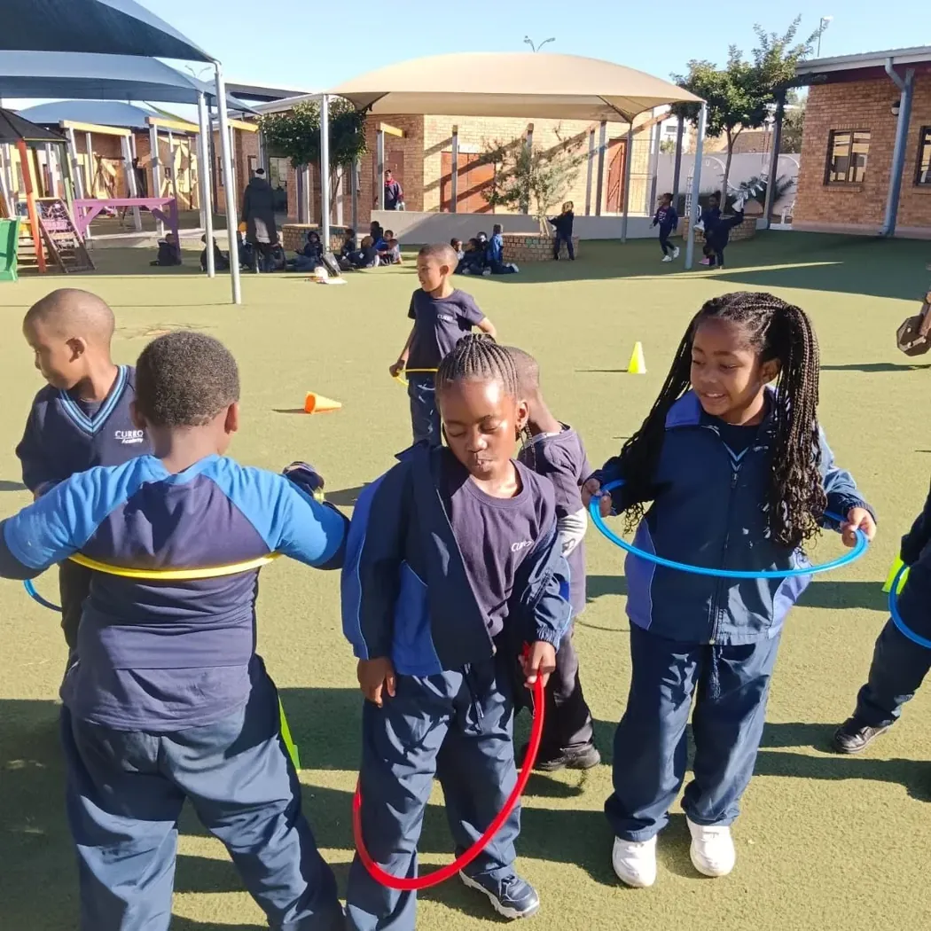 Curro Parkdene learners using colourful hoops in an outdoor movement activity